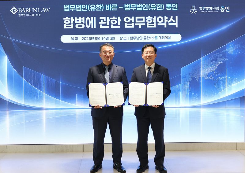 이동훈 바른 대표변호사(오른쪽)와 원창연 동인 대표변호사가 14일 서울 강남구 바른 대회의실에서 합병추진 업무협약서를 들고 기념사진을 촬영하고 있다. 법무법인 바른 제공