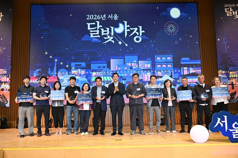 오세훈 서울시장(왼쪽 일곱번째)이 14일 서울시청에서 열린 '2026년 서울 달빛야장 조성사업 최종 시민참여평가' 행사에서 사업 대상으로 선정된 상권 담당자들과 기념촬영을 하고 있다. 서울시 제공