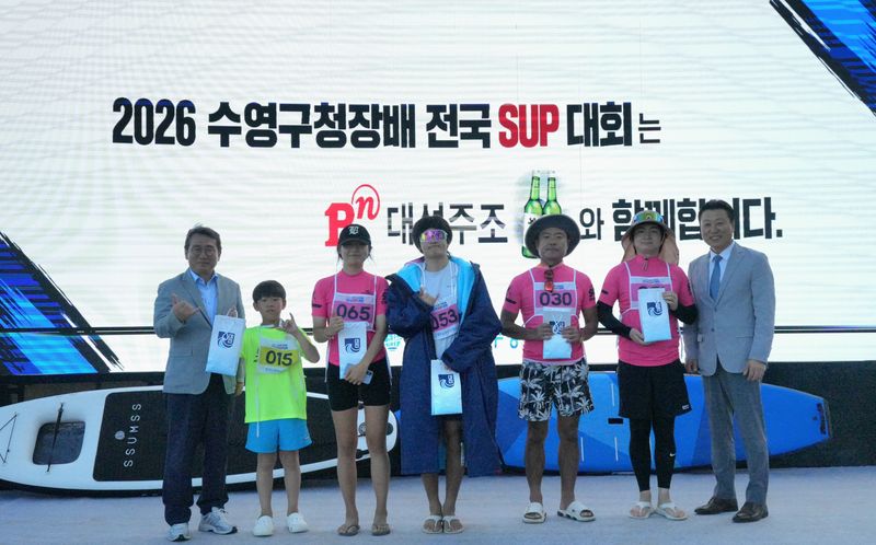 지난 12일 부산 광안리에서 열린 '2026 수영구청장배 전국 SUP 대회' 시상식에서 대선주조 최성욱 영업본부장(오른쪽 첫번째)과 수상자들이 기념촬영을 하고 있다. 대선주조 제공