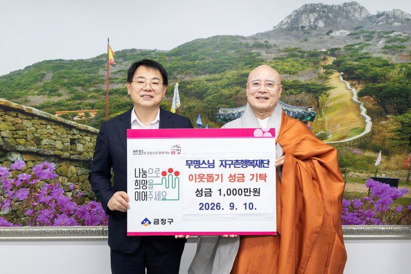 지난 10일 부산 금정구청을 찾은 무명스님(오른쪽)이 윤일현 구청장에 성금 1000만원을 기탁하며 함께 기념촬영하고 있다. 부산 금정구 제공