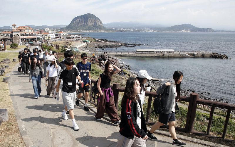 15일 제주 서귀포시 대정읍 송악산 둘레길에서 관광객들이 산방산과 해안 풍경을 바라보며 이동하고 있다. 9월 들어 제주 내국인 관광객 감소와 함께 김포~제주 등 국내 항공노선 공급 축소가 이어지면서 제주 관광업계의 항공 접근성 우려도 커지고 있다. 사진=뉴시스