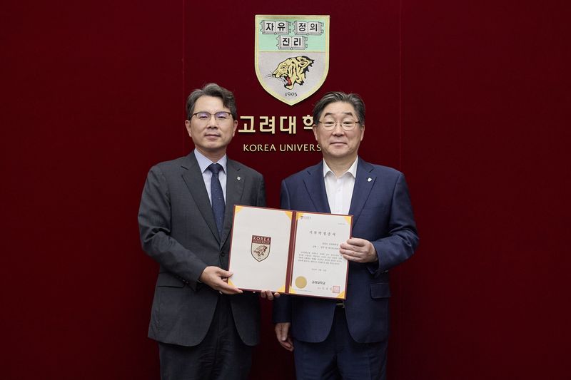 장길수 고려대 공과대학장(왼쪽)이 14일 서울 안암동 고려대 본관에서 김동원 고려대 총장에게 연구동 건축기금 1억원을 전달한 뒤 기념 촬영을 하고 있다. 고려대 제공