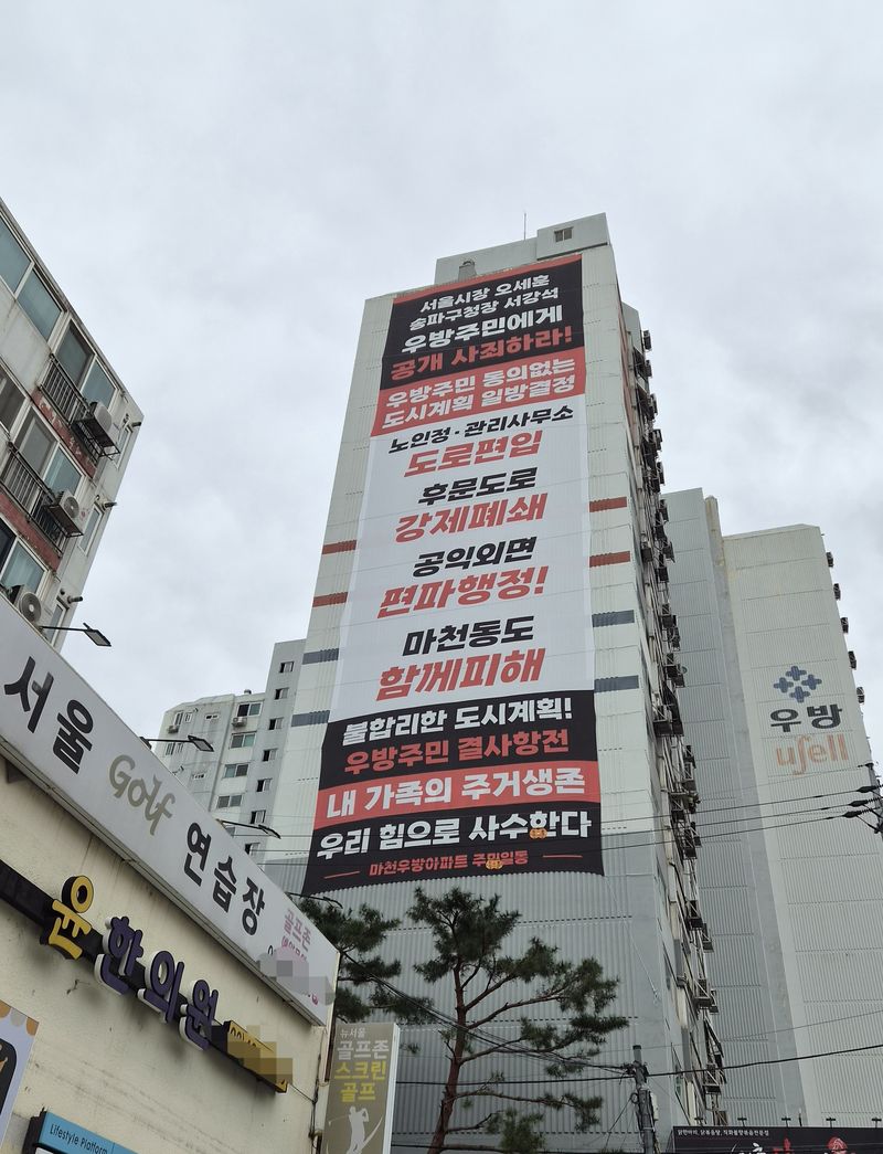 서울 송파구 마천우성아파트 외벽에 주민들의 '마천1구역 도시 계획 반발' 현수막이 걸려있다. 사진=전민경 기자