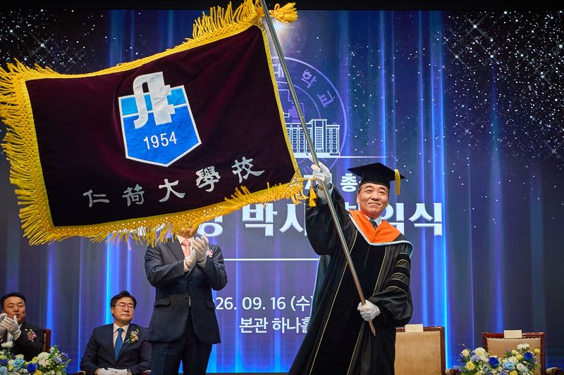 16일 최기영 인하대 총장이 취임식에서 교기를 흔들고 있다. 인하대 제공.