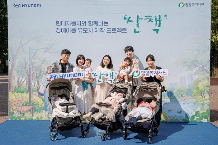 지난 14일 서울 광진구 서울어린이대공원에서 열린 장애아동 유모차 제작 프로젝트 '산책' 행사에서 참가 가족들이 기념촬영을 하고 있다. 밀알복지재단 제공