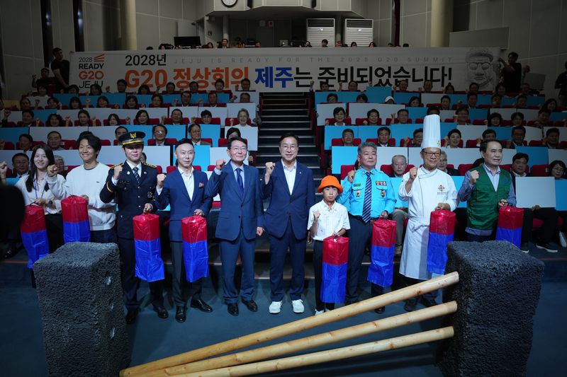 16일 제주웰컴센터에서 열린 ‘2028년 G20 정상회의 제주 개최 범국민추진위원회’ 출범식에서 호텔리어·자치경찰·요리사 등 도민 대표와 주요 참석자들이 제주 전통 대문인 정낭을 활용한 세리머니 뒤 G20 제주 개최를 기원하고 있다. 사진=제주특별자치도 제공