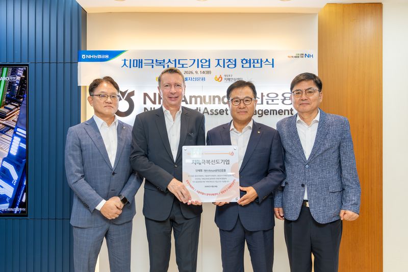 지난 14일 길정섭 NH아문디자산운용 대표이사(왼쪽 세번째)와 니콜라 시몽 부대표(왼쪽 두번째), 주요 임원진들이 서울 여의도 본사에서 열린 치매극복선도기업 지정 현판식을 마친 후 기념사진을 촬영하고 있다. NH아문디자산운용 제공