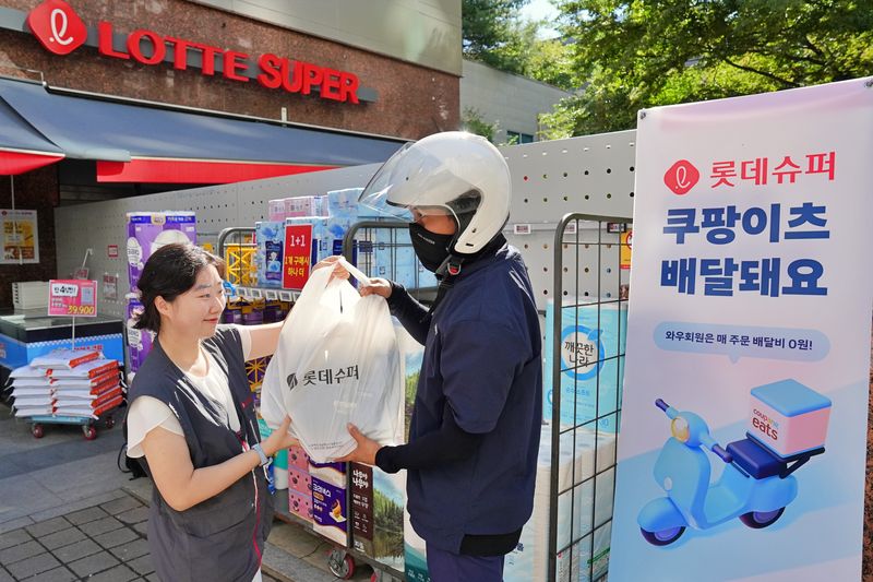 서울 송파구 롯데슈퍼 신천점에서 직원이 배달기사에게 주문 상품을 전달하고 있다. 롯데슈퍼 제공