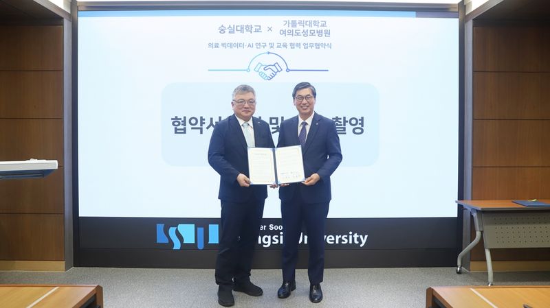 이윤재 숭실대학교 총장(오른쪽)과 강원경 여의도성모병원장이 의료 빅데이터·인공지능 연구 및 교육 협력을 위한 업무협약을 맺은 뒤 협약서를 들어 보이고 있다. 숭실대 제공