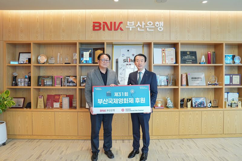 ‘제31회 부산국제영화제 성공 개최를 위한 후원금 전달식’에서 박광수 부산국제영화제 이사장과 김성주 BNK부산은행장(오른쪽)이 기념촬영하고 있다. 부산국제영화제 사무국 제공