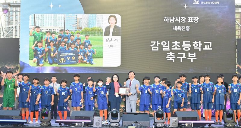 19일 오후 하남미사호수공원 잔디광장에서 열린 '2026 하남 이성산성 문화제'에서 이현재 하남시장(가운데)과 정미자 감일초 교장, 축구부 학생들이 표창을 받은 뒤 기념촬영을 하고 있다. 사진=김경수 기자