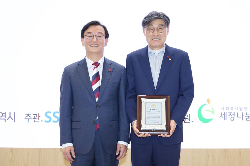 제18회 부산광역시 사회공헌장 나눔 부문 으뜸장을 수상한 정성우 ㈜지맥스 회장(오른쪽)이 전재수 부산시장과 기념촬영을 하고 있다. 부산사랑의열매 제공