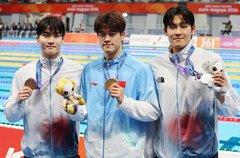 20일 도쿄 아쿠아틱스 센터에서 열린 2026 아이치·나고야 아시안게임 수영 남자 100m 자유형 시상식에서 은메달을 획득한 김영범과 동메달을 획득한 황선우가 메달을 들어보이고 있다. 오른쪽부터 은메달 김영범, 금메달 중국의 판잔러, 동메달 황선우. 2026.9.20 ⓒ 뉴스1 김민지 기자