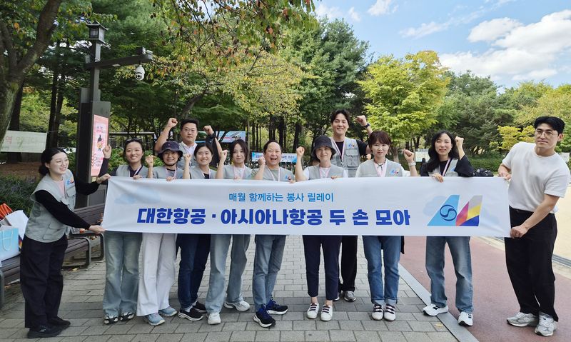 환경정화 활동에 참여한 '두 손 모아' 봉사단 소속 대한항공, 아시아나항공 임직원들이 기념사진을 촬영하고 있다. 대한항공 제공
