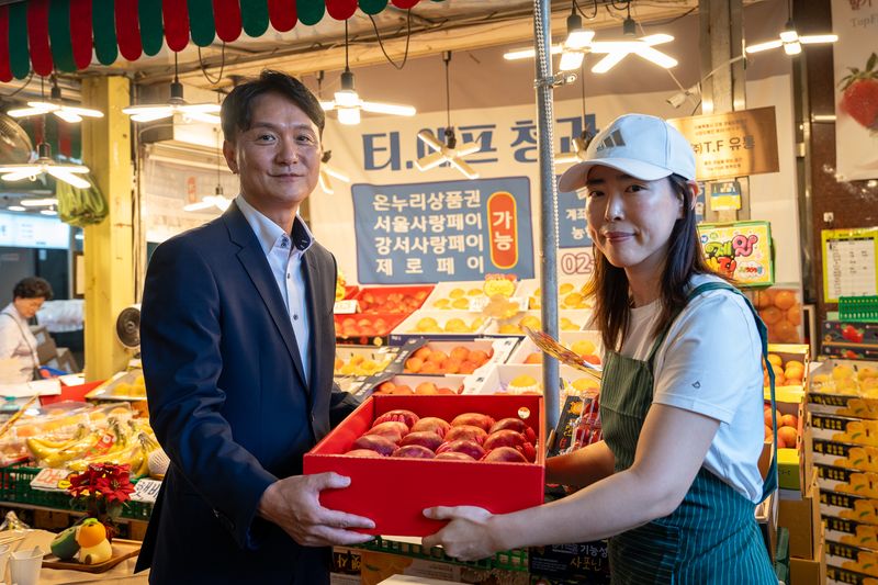 엄주성 키움증권 대표(왼쪽)가 지난 18일 오전 금융권 추석 나눔 행사에 참여, 서울 강서구 방신전통시장에서 사과를 구매하고 있다. 구매한 물품은 지역사회 취약계층과 사회복지단체에 전달했다. 키움증권 제공