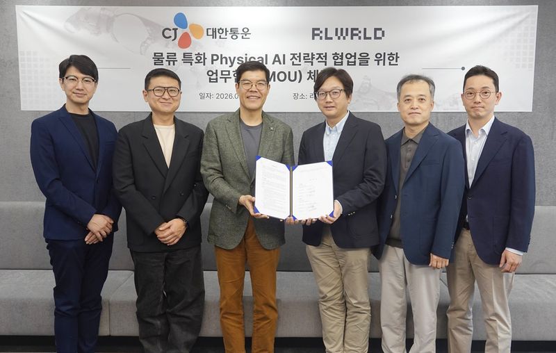 CJ대한통운과 리얼월드의 '물류특화 피지컬AI 전략적 협업을 위한 업무협약 체결식'에 참석한 양사 관계자가 기념 사진을 촬영하고 있다. CJ대한통운 제공
