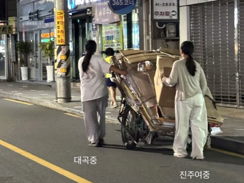 교복을 입은 중학생 두 명이 밤늦은 진주 시내 도로에서 폐지가 가득 실린 리어카를 앞뒤로 나눠 끌고 고물상으로 향하고 있다. /사진=스레드