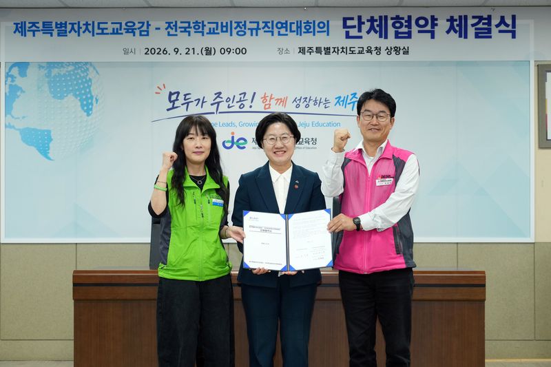 21일 오전 제주특별자치도교육청 본관 상황실에서 고의숙 제주도교육감(가운데)과 전국학교비정규직연대회의 관계자들이 단체협약서를 들고 기념촬영을 하고 있다. 노사는 97차례 교섭 끝에 144개조, 593개 항목에 합의했다. 사진=제주특별자치도교육청 제공