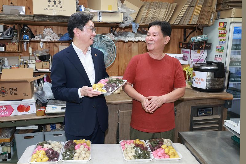 이억원 금융위원장(왼쪽)이 21일 추석을 앞두고 서울 종로구 통인시장을 찾아 상인과 이야기를 나누고 있다. 금융위원회 제공