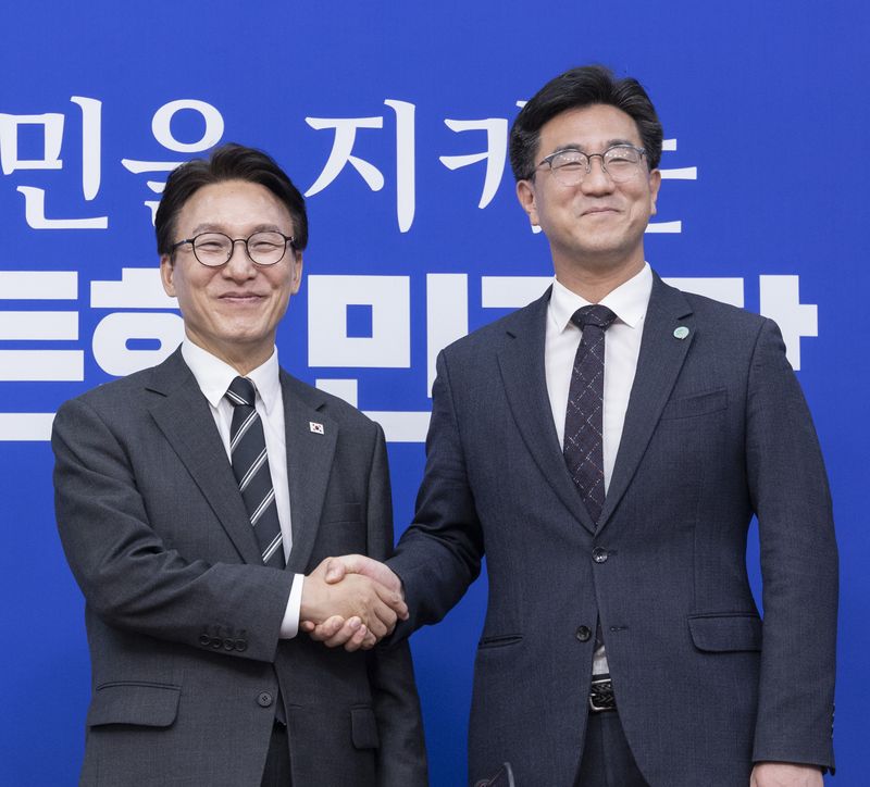 더불어민주당 김민석 대표(왼쪽)가 21일 국회에서 취임 인사차 방문한 기본소득당 오준호 대표를 만나 악수하고 있다. 연합뉴스