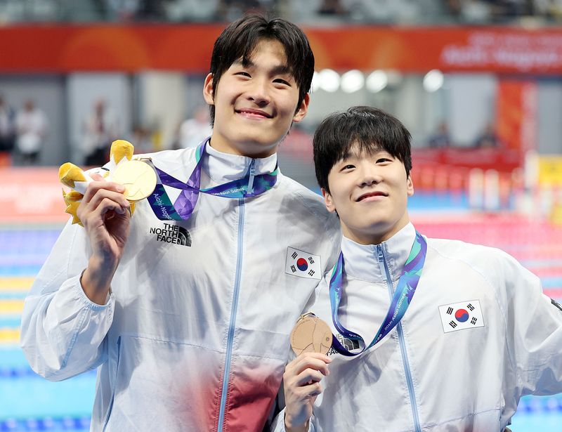 21일 일본 도쿄도 고토구 도쿄아쿠아틱스센터에서 열린 2026 아이치·나고야 아시안게임 경영 남자 자유형 50m 시상식에서 금메달을 획득한 김영범(왼쪽), 동메달을 획득한 지유찬이 포즈를 취하고 있다. 뉴시스
