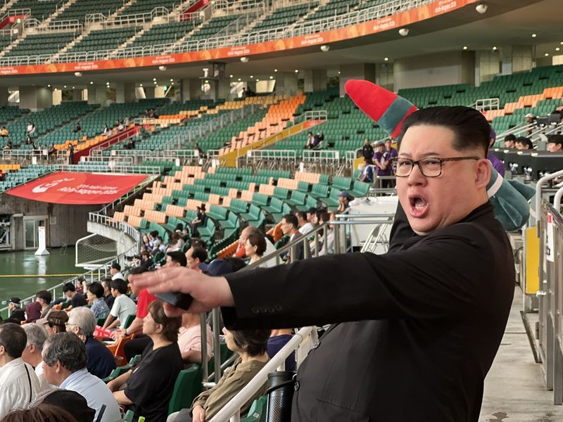 21일(현지시간) 일본 시즈오카 스타디움 에코파에서 열린 2026 아이치·나고야 아시안게임 여자축구 남북전에서 중국계 호주인 인플루언서 하워드 리가 김정은 북한 국무위원장을 흉내내고 있다. /사진=연합뉴스