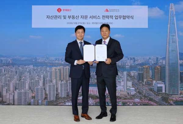 21일 서울 송파구 롯데월드타워 113층 EBC에서 장재훈 롯데물산 대표이사와 황점상 쿠시먼앤드웨이크필드 코리아 대표(왼쪽부터)가 기념 촬영을 하고 있다. 롯데물산 제공