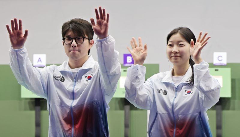 22일 일본 아이치현 종합 사격장에서 열린 2026 아이치·나고야 아시안게임 사격 10m 공기소총 혼성 단체전 시상식에서 은메달을 차지한 한국 반효진(오른쪽)과 박하준이 손을 들며 시상대에 오르고 있다. 연합뉴스