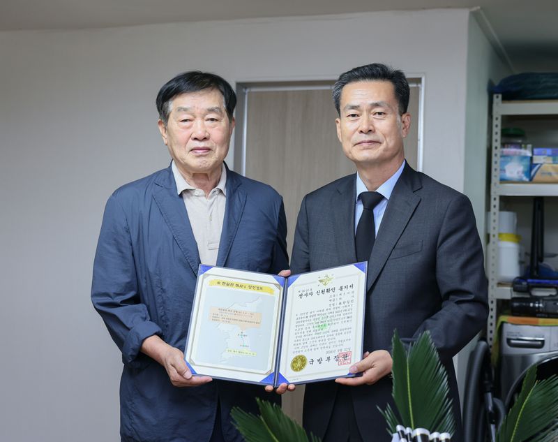 22일 오전, 전병희 국방부 유해발굴감식단장(오른쪽)과 고 한길진 하사의 아들 한봉진 씨(왼쪽, 83세)가 기념사진을 촬영하고 있다. 국방부 제공