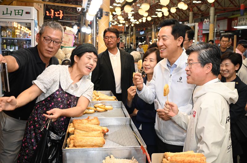 오세훈 서울시장(오른쪽 두번째)이 22일 서울 중구 신중앙시장에서 '디자인혁신 전통시장 기공식'에 참석한 후 시장 내 점포를 찾아 상인들과 기념촬영을 하고 있다. 서울시 제공