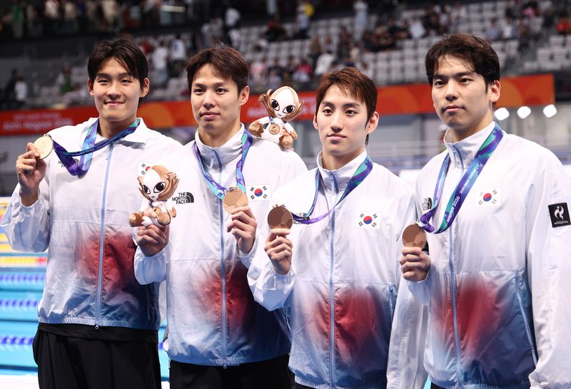 22일 도쿄 아쿠아틱스 센터에서 열린 2026 아이치·나고야 아시안게임 수영 남자 400m 혼계영에서 동메달을 획득한 한국 대표팀이 메달을 목에 걸고 기념촬영하고 있다. 왼쪽부터 김영범, 양재훈, 최동열, 이주호. 연합뉴스