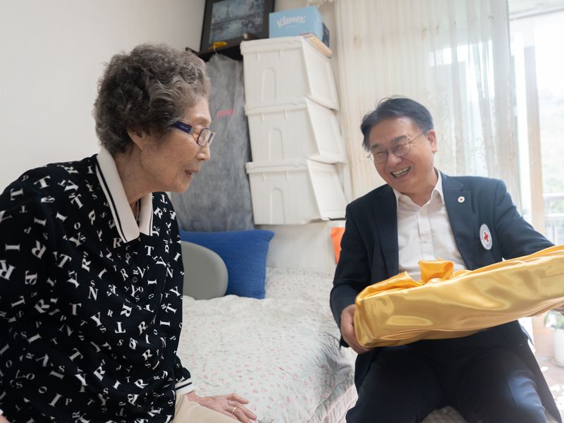 원폭피해자 오재봉씨(왼쪽)가 서울 서대문구 자택에서 허정구 대한적십자사 재외동포지원본부장으로부터 추석 위로물품을 받고 있다. 대한적십자사 제공