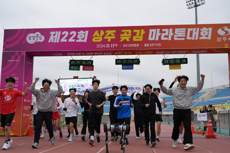 지난 2024년 11월 열린 상주 곶감 마라톤 대회에서 사족보행로봇 '라이보2'가 마라톤 완주 결승 지점을 통과하고 있는 모습. KAIST 참여 연구진들이 완주를 기뻐하고 있다. KAIST 제공