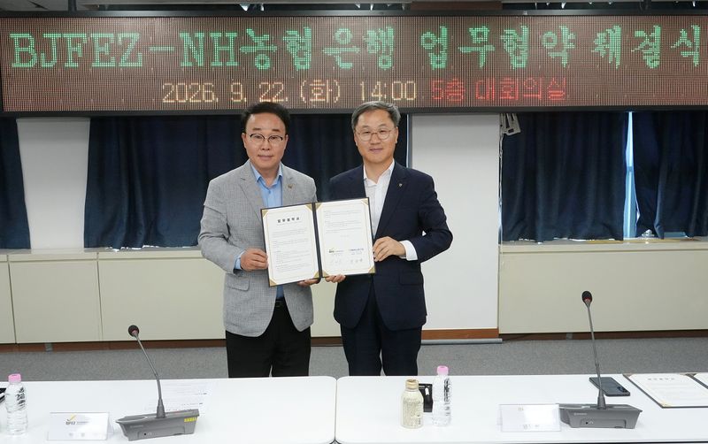 22일 엄을용 농협은행 기업금융부문 부행장(오른쪽)과 부산진해경제자유구역청 박성호 청장이 부산에서 부산진해경제자유구역(BJFEZ) 입주기업 대상 종합금융서비스 지원을 위한 업무협약을 체결하고 사진 촬영을 하고 있다. 농협은행 제공