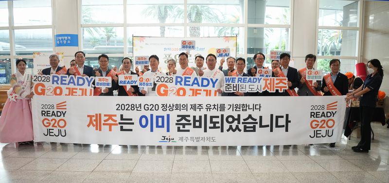 23일 제주국제공항 국내선 도착 대합실에서 위성곤 제주도지사와 도내 공공기관장 등이 ‘2028 READY G20 JEJU’와 ‘제주는 이미 준비되었습니다’ 문구가 적힌 현수막을 들고 G20 정상회의 제주 유치를 알리고 있다. 이날 합동 홍보에는 도내 17개 공공기관장과 제주도관광협회가 참여했다. 사진=제주특별자치도 제공