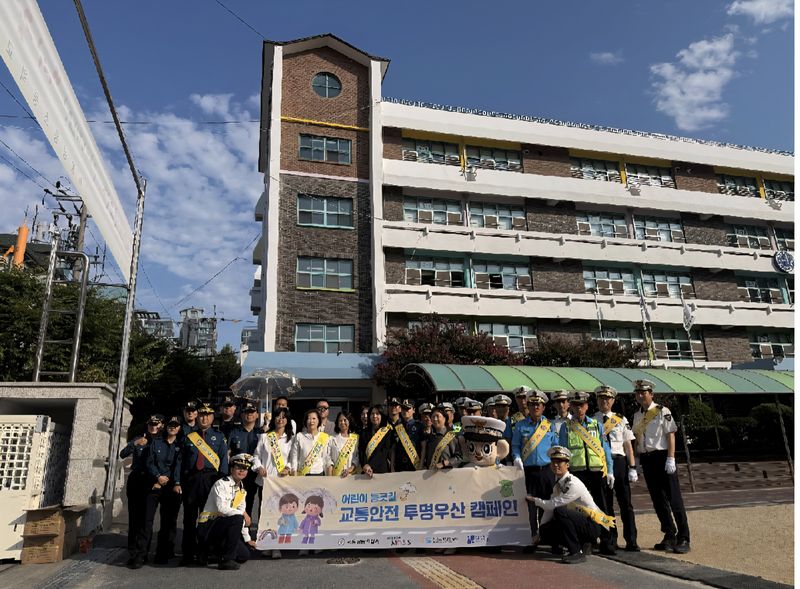 서울강남경찰서 관계자들이 23일 서울 강남구 삼릉초등학교 정문과 후문에서 어린이 등굣길 교통안전을 위한 '투명우산 합동 캠페인'을 진행한 뒤 기념촬영을 하고 있다. 서울강남경찰서 제공
