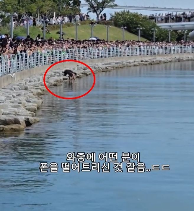 부산 북항친수공원에서 한 남성이 안전 펜스를 넘어 수로 가까이 내려가는 모습이 포착돼 화제가 되고 있다. (사진='KNN NEWS' 캡처)