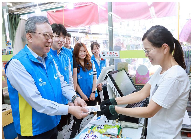 정상혁 신한은행장(왼쪽)이 지난 15일 '희망을 나누는 추석맞이 상생 캠페인'의 일환으로 전통시장에서 물품을 구매하고 있다. 신한금융 제공