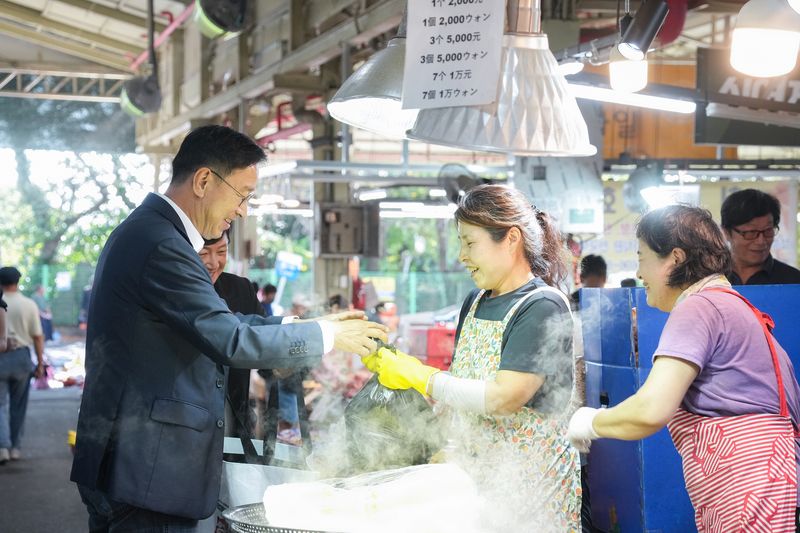 위성곤 제주특별자치도지사가 24일 서귀포향토오일시장에서 상인에게 물품을 건네받으며 이야기를 나누고 있다. 위 지사는 이날 시장을 돌며 추석 성수품 가격과 명절 대목의 판매 상황을 살폈다. 사진=제주특별자치도 제공