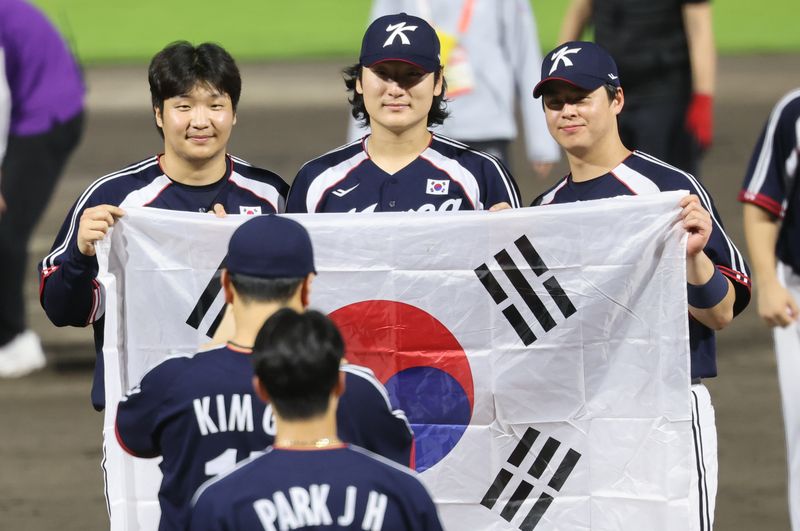 27일 일본 아이치현 도요하시 시민구장에서 열린 2026 아이치·나고야 아시안게임 야구 결승전 대한민국과 일본의 경기에서 3대1로 승리하며 금메달을 차지한 대한민국 문보경(왼쪽부터), 곽빈, 노시완이 기념 촬영을 하고 있다. 뉴스1