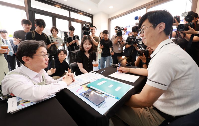 이억원 금융위원장이 1차 '청년미래적금' 가입 신청이 시작된 지난 6월 서울 성동구 신한빌딩에서 상담받는 청년들과 대화를 나누고 있다. 2026.6.22 ⓒ 뉴스1 이호윤 기자