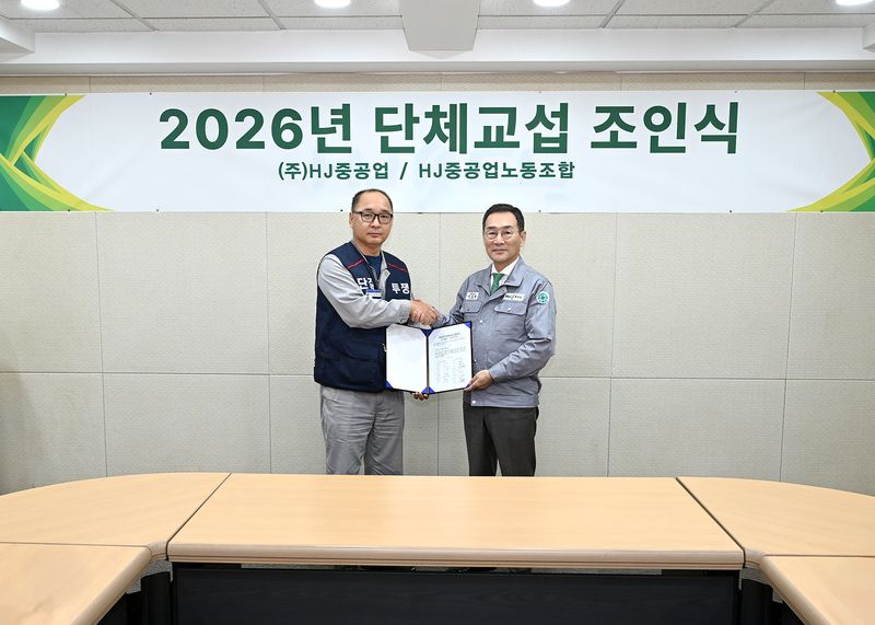 HJ중공업 유상철 대표이사(오른쪽)와 HJ중공업노동조합 김하동 위원장이 28일 진행된 단체교섭 조인식에서 악수를 하고 있다. HJ중공업 제공