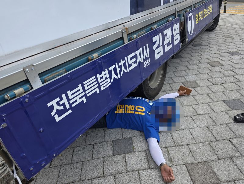 지난 6월1일 김관영 전북도지사 후보 유세차 밑에 드러누운 이원택 후보 선거운동원. 뉴스1