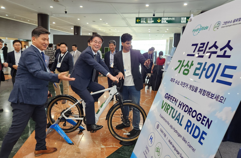 양덕순 제주대학교 총장이 최근 제주국제컨벤션센터에서 열린 ‘2026 그린수소 글로벌 포럼’에서 하이드로라이드가 개발 중인 수소자전거를 체험하고 있다. 김상재 하이드로라이드 대표(왼쪽)가 수소자전거의 작동방식을 설명하고 있다. 사진=하이드로라이드 제공