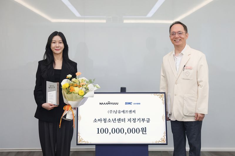 삼남유숙 남유에프엔씨 대표(왼쪽)가 삼성서울병원 소아청소년센터에 1억원을 기부한 후 박승우 삼성서울병원 원장과 기념촬영을 하고 있다. 삼성서울병원 제공