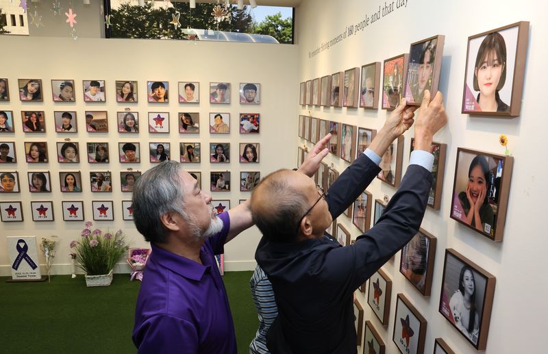 지난 1일 서울 종로구 적선현대빌딩에 마련된 별들의 집에서 열린 10.29 이태원 참사 4주기 '기억과 애도의 날' 선포 기자회견에서 160번째 희생자 고 백형준 님 가족이 고인의 사진 액자를 걸고 있다. 연합뉴스