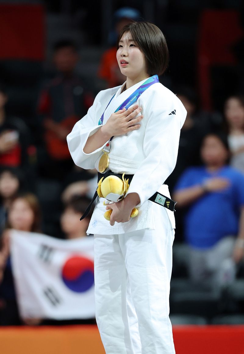 1일 (현지 시간) 일본 아이치현 나고야시 아이치 인터네셔날 아레나에서 열린 2026 아이치·나고야 아시안게임 유도 여자 57kg급 시상식에서 금메달을 획득한 한국 허미미가 국민의례를 하고 있다. 뉴시스