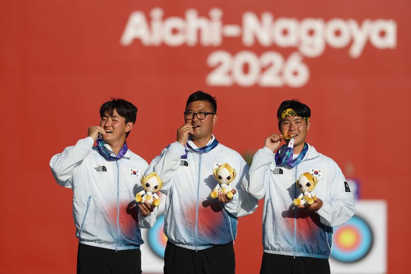 대한민국 김제덕(왼쪽부터), 김우진, 이우석이 2일 일본 오카자키 중앙종합공원 다목적광장에서 열린 2026 아이치·나고야 아시안게임 양궁 리커브 남자 단체전 결승 시상식에서 금메달을 깨물고 세리머니를 하고 있다. 2026.10.2 ⓒ 뉴스1 김민지 기자