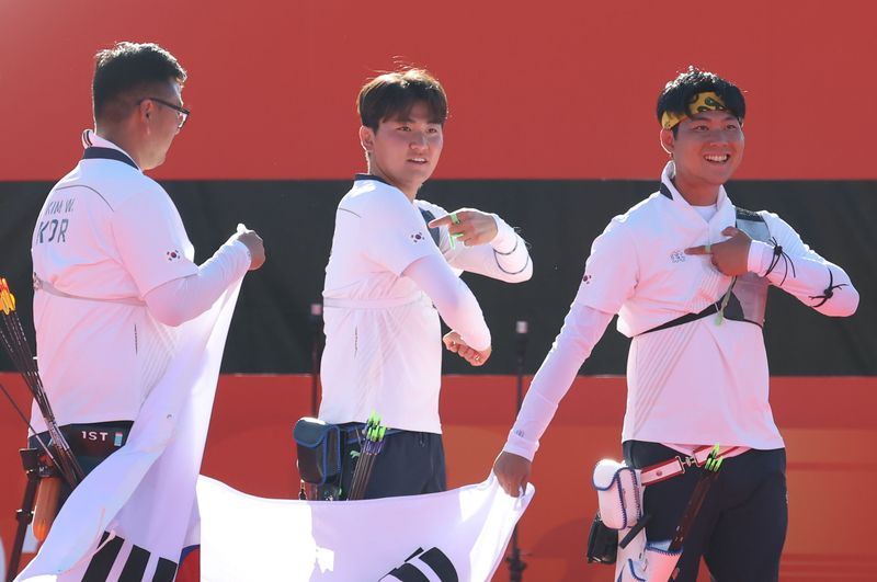 대한민국 김우진 이우석 김제덕이 2일 일본 오카자키 중앙종합공원 다목적광장에서 열린 2026 아이치·나고야 아시안게임 양궁 리커브 남자 단체전 결승 대한민국과 인도의 경기에서 금메달을 확정 지은 후 태극기를 들고 기뻐하고 있다. 2026.10.2 ⓒ 뉴스1 김민지 기자