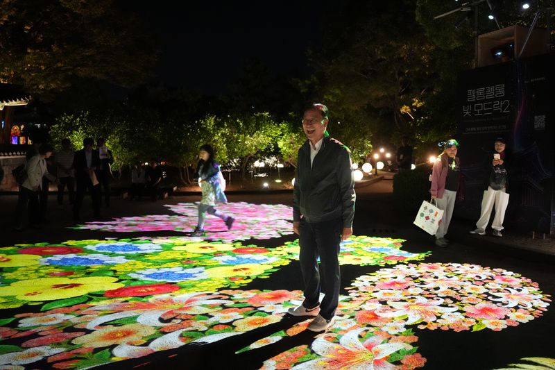 제주목 관아 야외 공간 바닥에 꽃을 형상화한 미디어아트 영상이 펼쳐진 가운데 위성곤 제주도지사와 관람객들이 전시를 둘러보고 있다. 제주도는 역사문화시설의 야간 이용을 늘리고 주변 상권까지 관광객의 이동을 이어가는 방안을 검토하고 있다. 사진=제주특별자치도